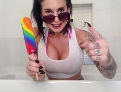 Dark-haired slut with fake boobs fucks herself in the bathroom
